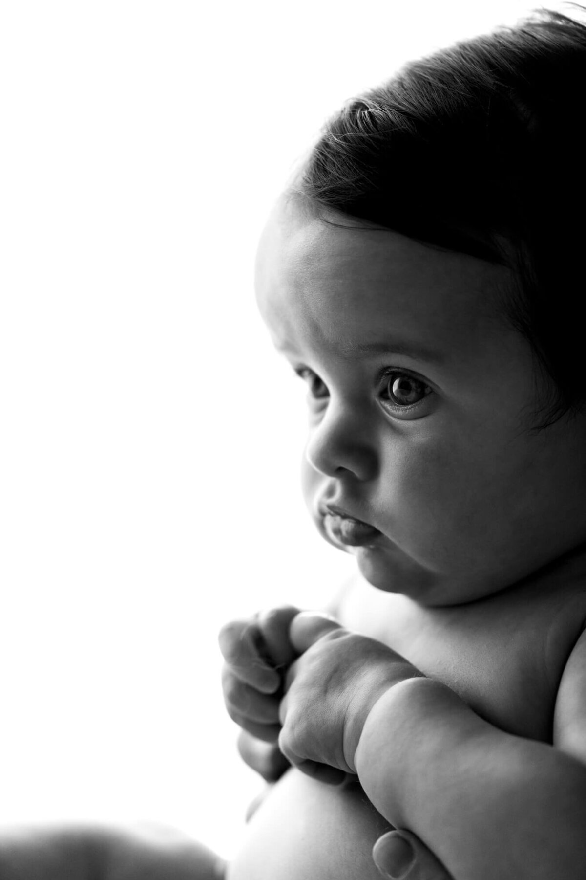 Black and white studio portrait of a four month old baby girl.