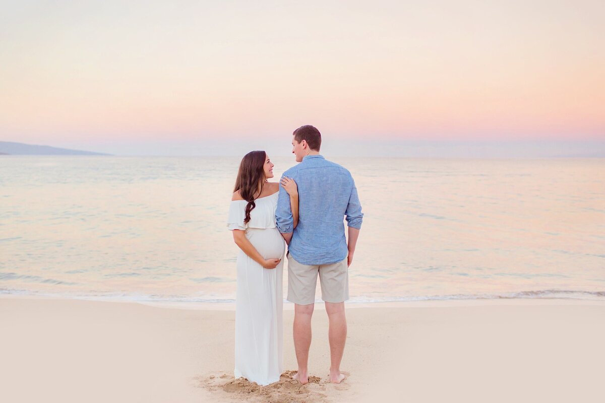 Couple looking at one another during their White Rock Beach portraits in Wailea by Love + Water