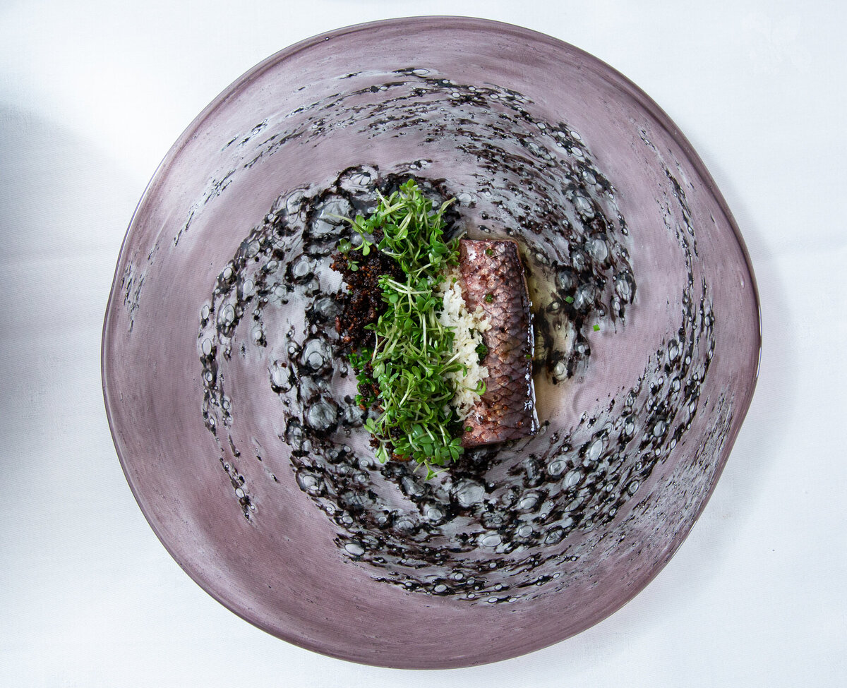 Pickled herring on purple glass plate