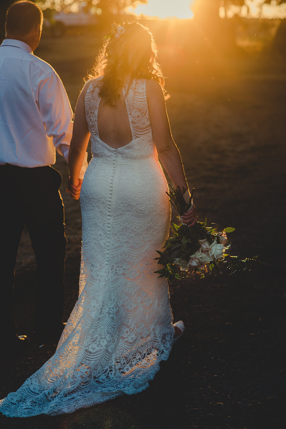 bride and groom walking in gold light