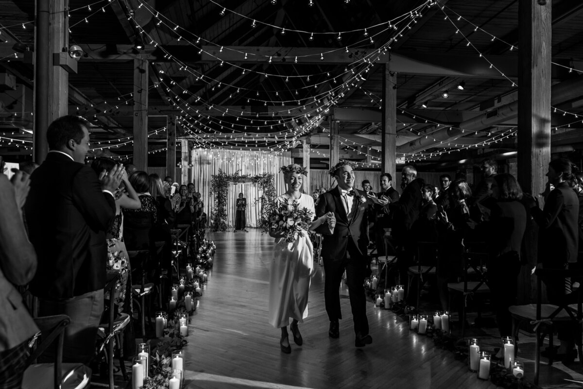 String lights cover the ceiling while a bride and groom get married at the Ravenswood Art Center in Chicago, Illinois