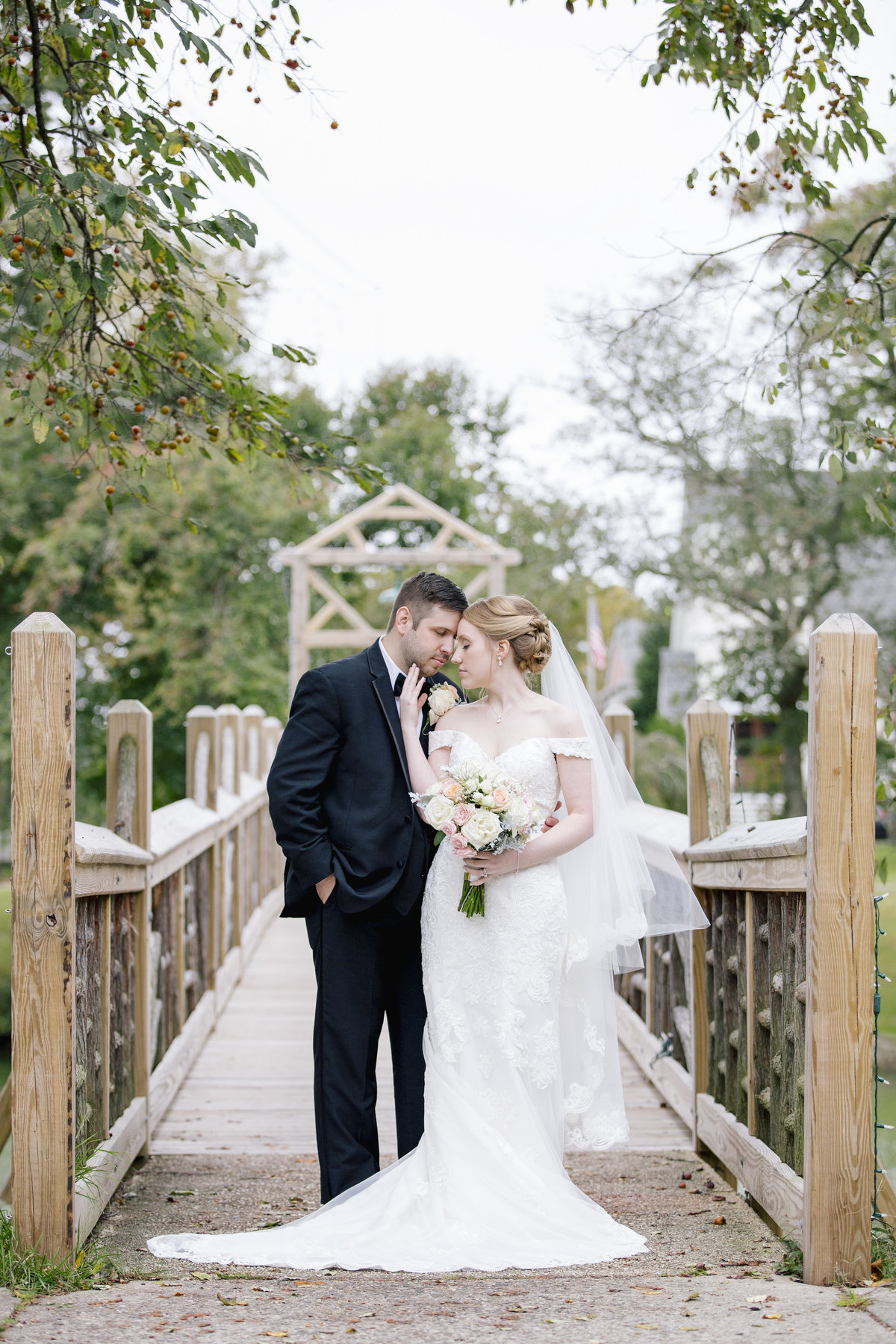 bride and groom on bridge at spring lake park wedding