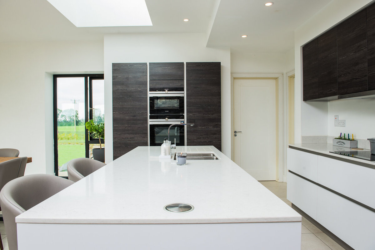 Modern kitchen with black and  white units and quartz island