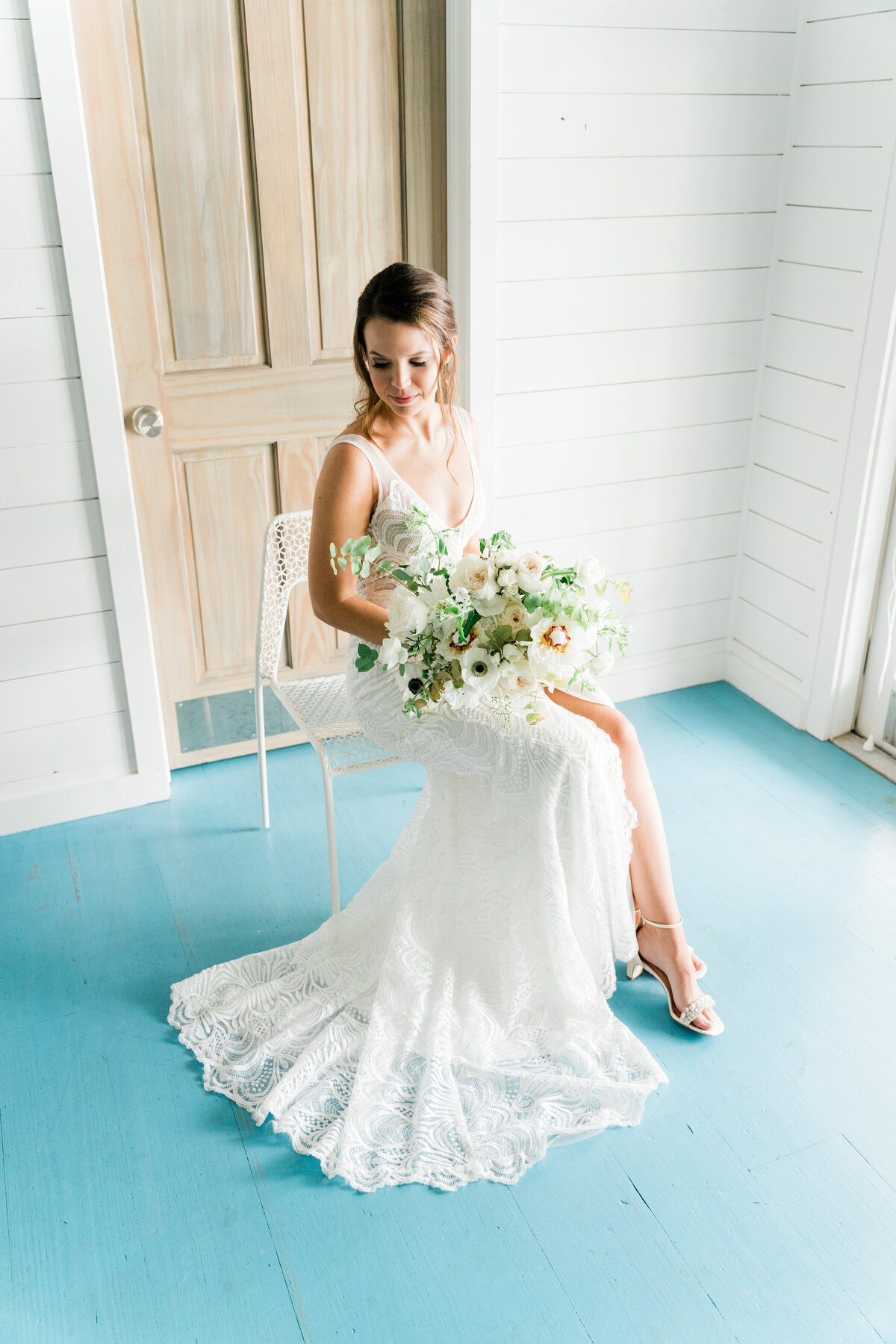 Bride in white chair on blue floor in Alabama
