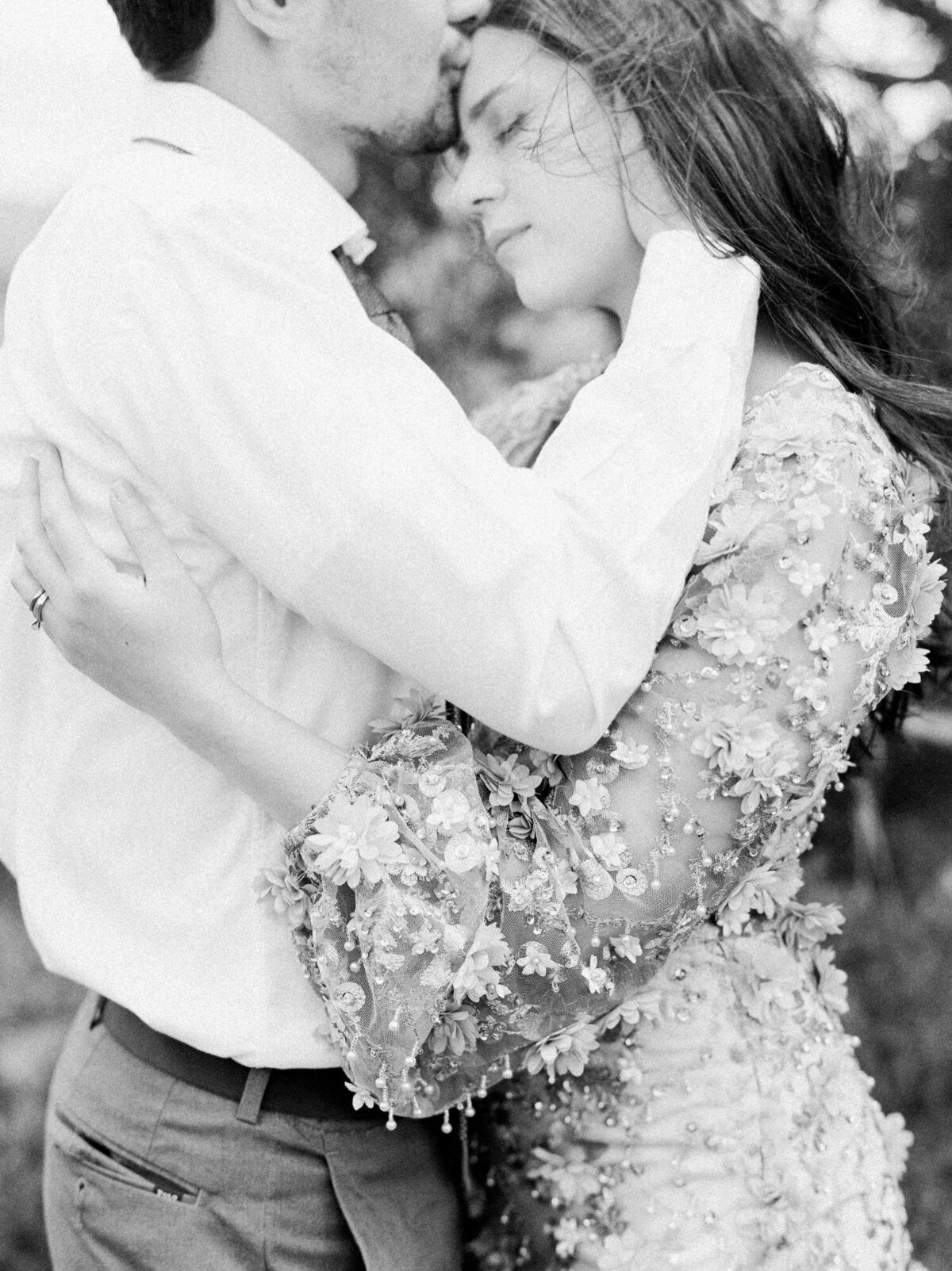 Black-and-white-image-of-forehead-kiss-with-trees-around-them-in-vail-Colorado.jpg