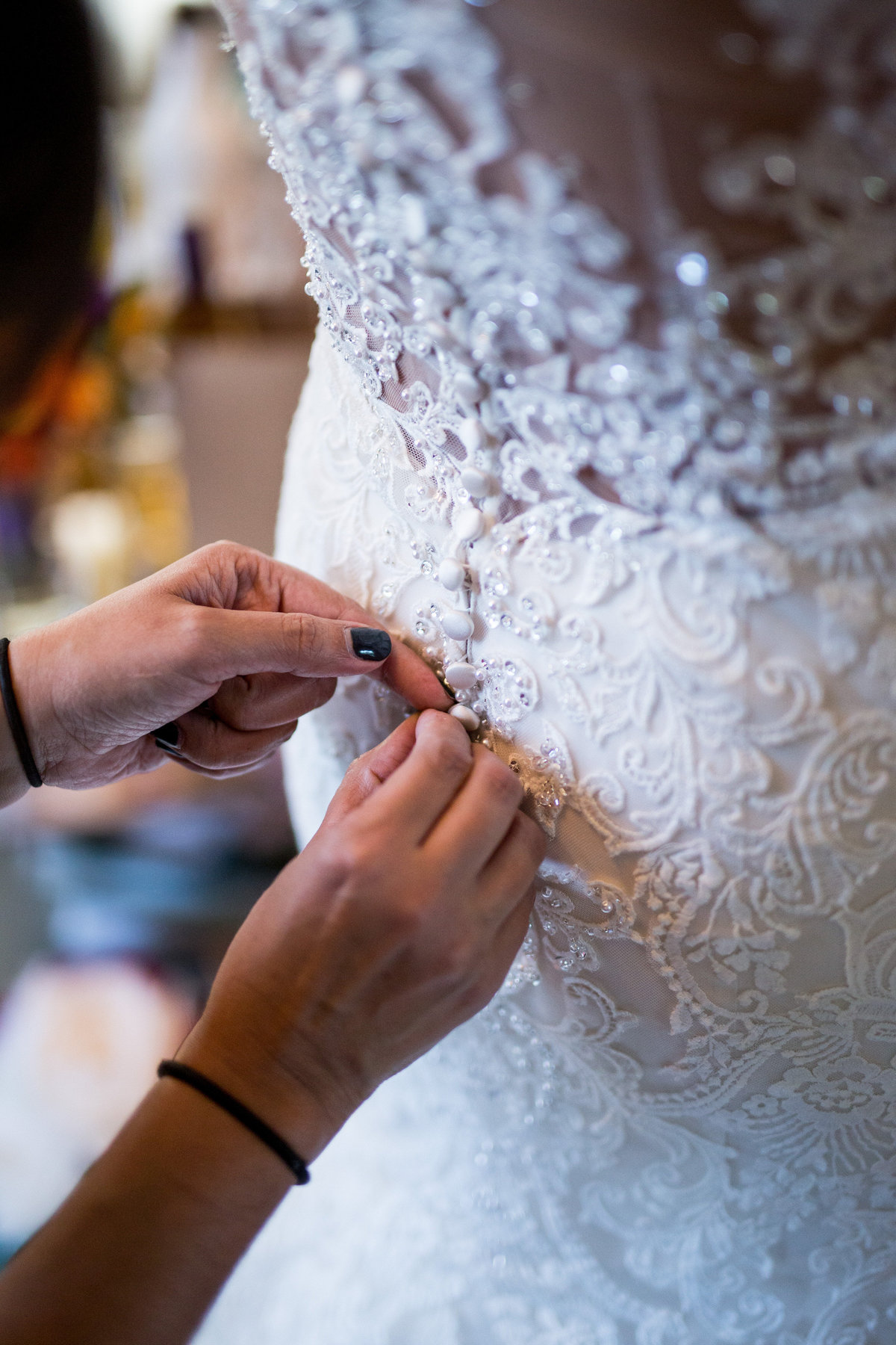 mother of bride buttoning bridal gown of bride during getting ready in san antonio wedding
