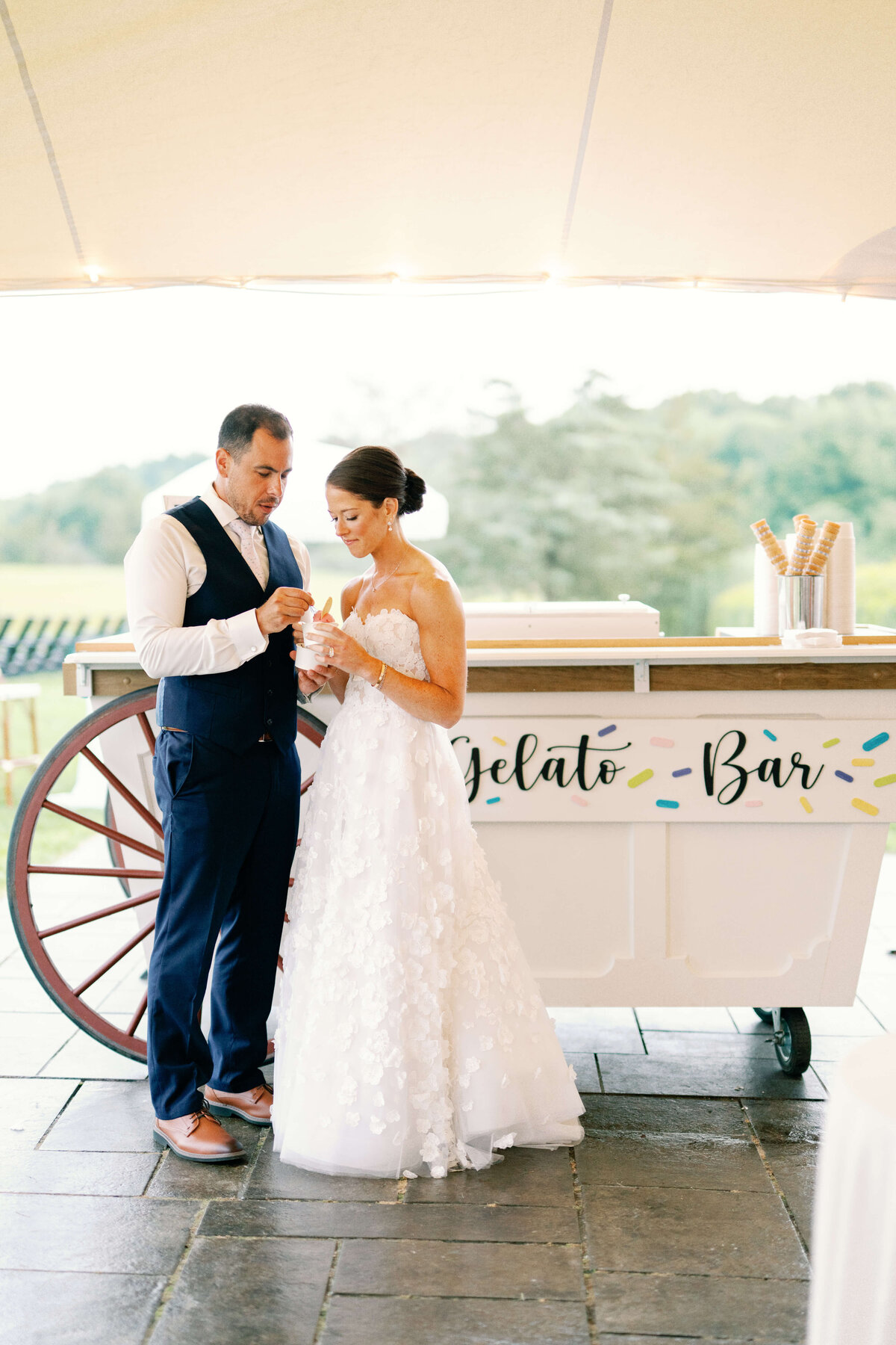bride and groom in front of  gelato cart after wedding ceremony