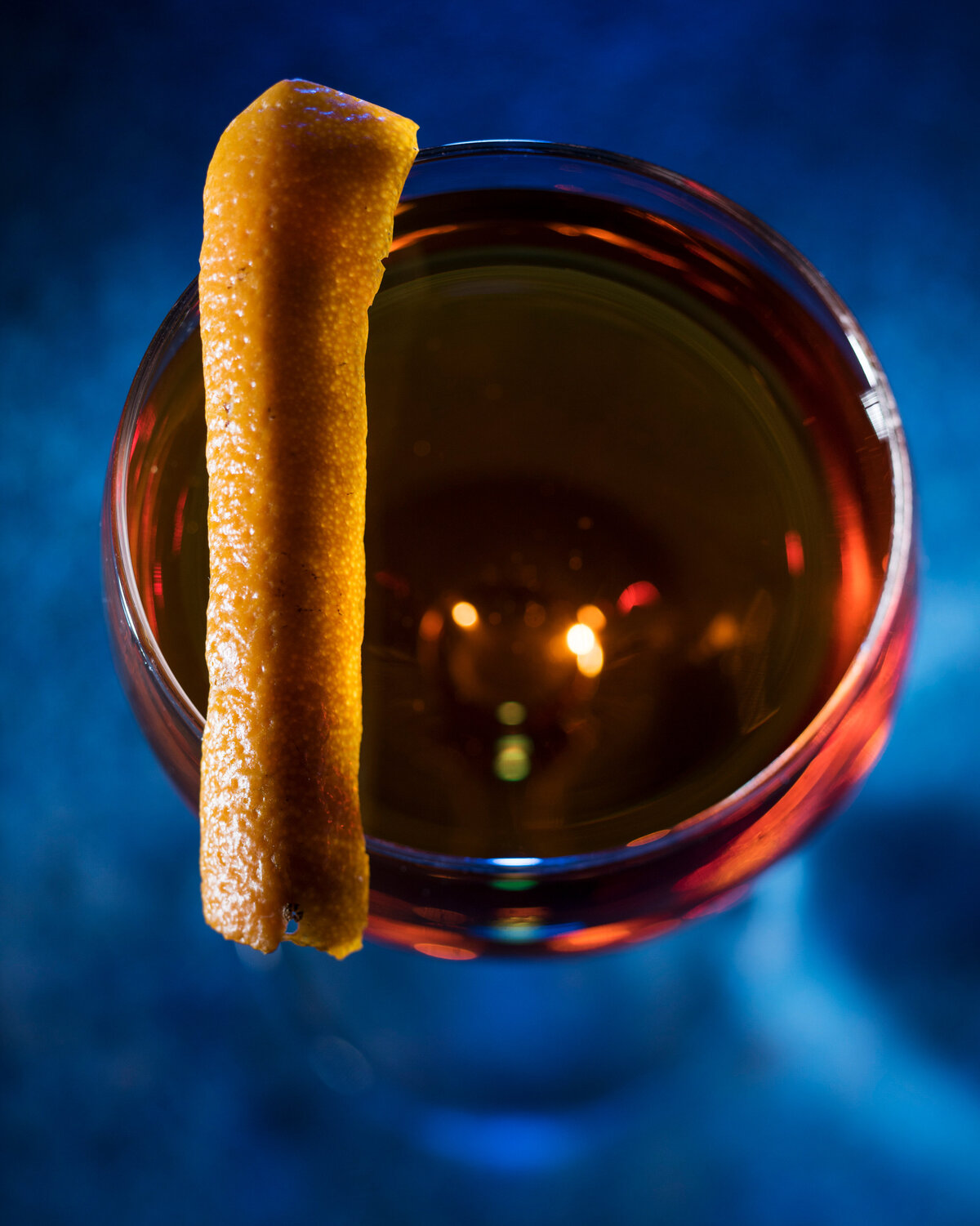 A cinnamon stick on top of a cocktail