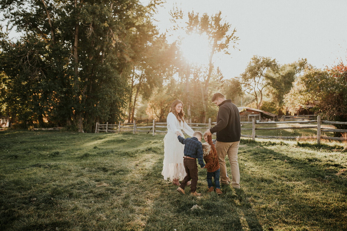 Montana family gathered together in front of a barn and fence.