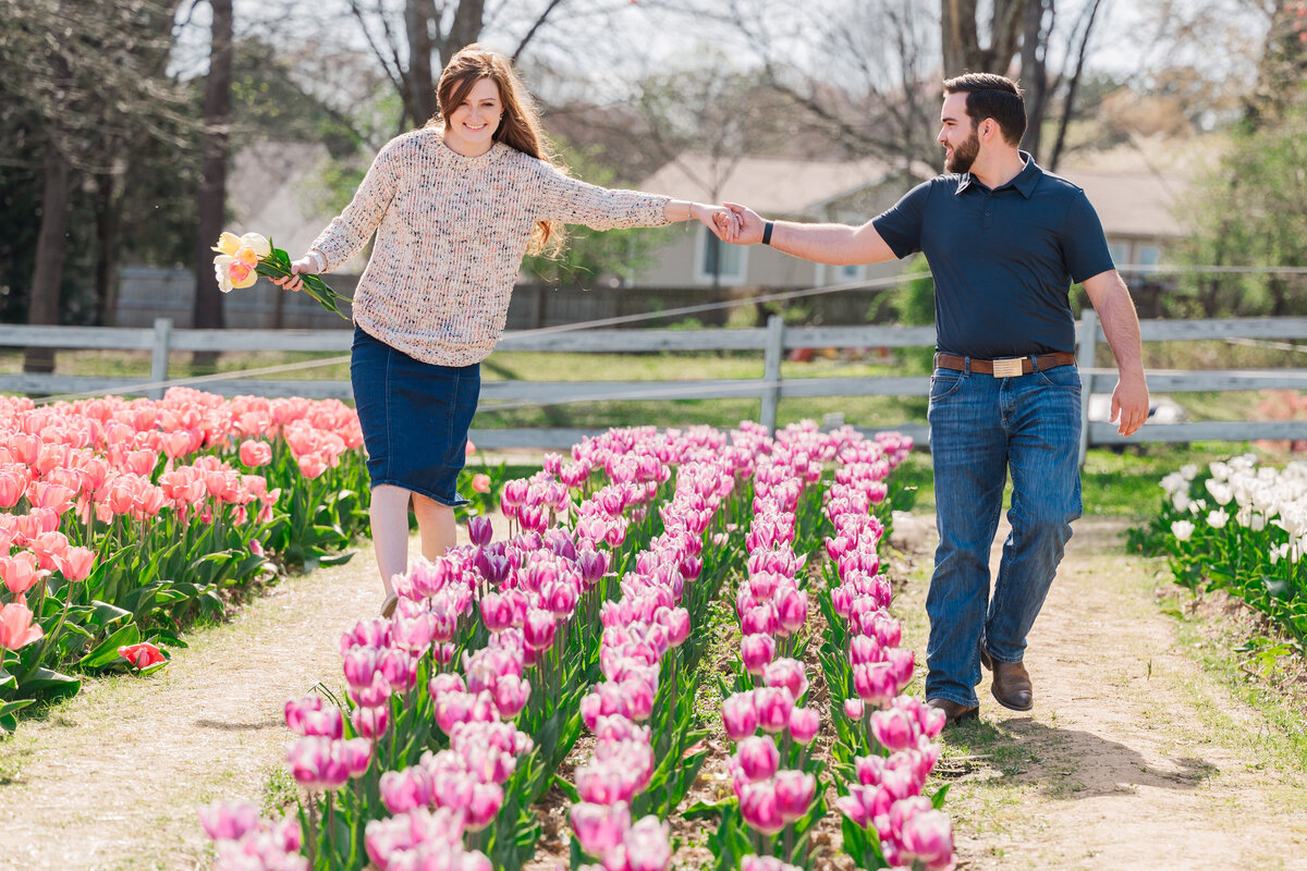 A playful engaged couple walking