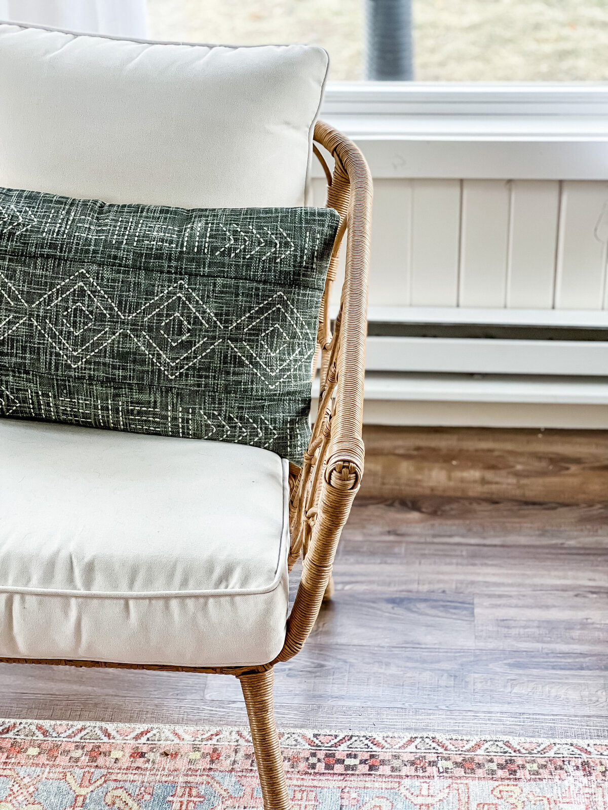 A lumbar pillow with a geometric pattern sicks on a white patio chair
