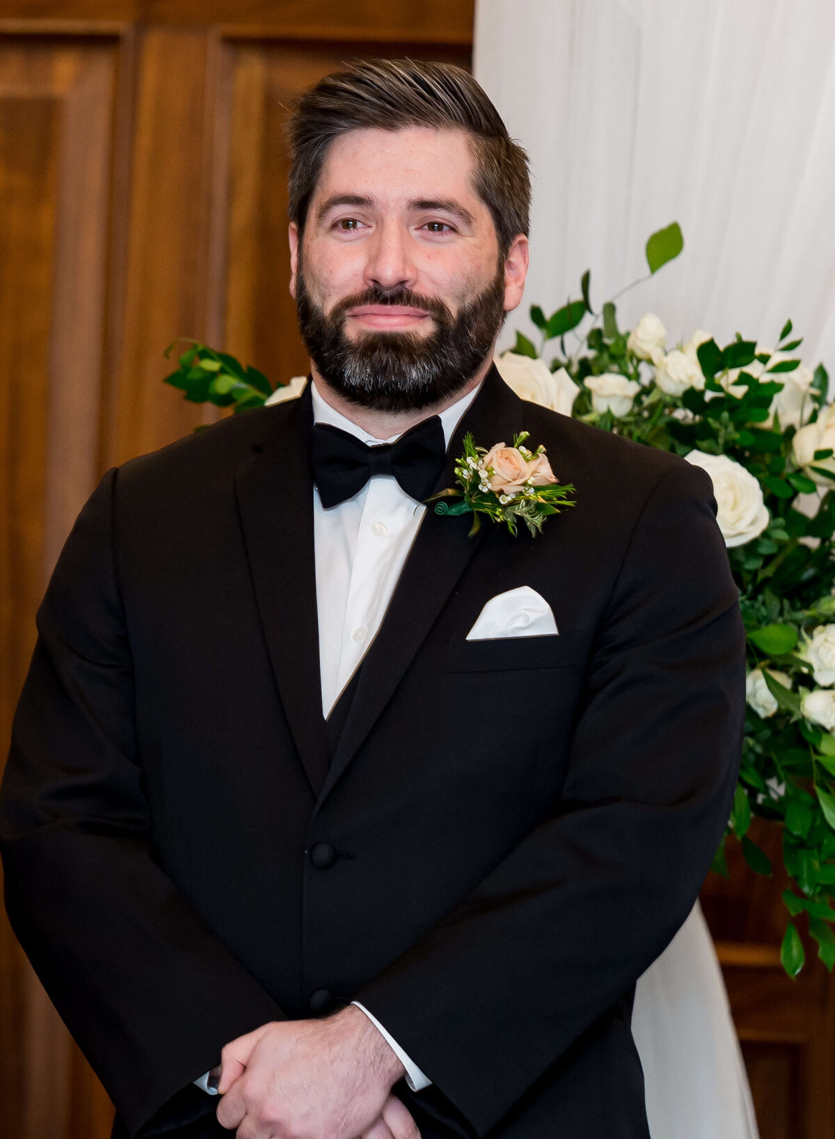 a portrait of an Ottawa groom in a black tuxedo at the altar.  Taken indoors at the Chateau Laurier hotel