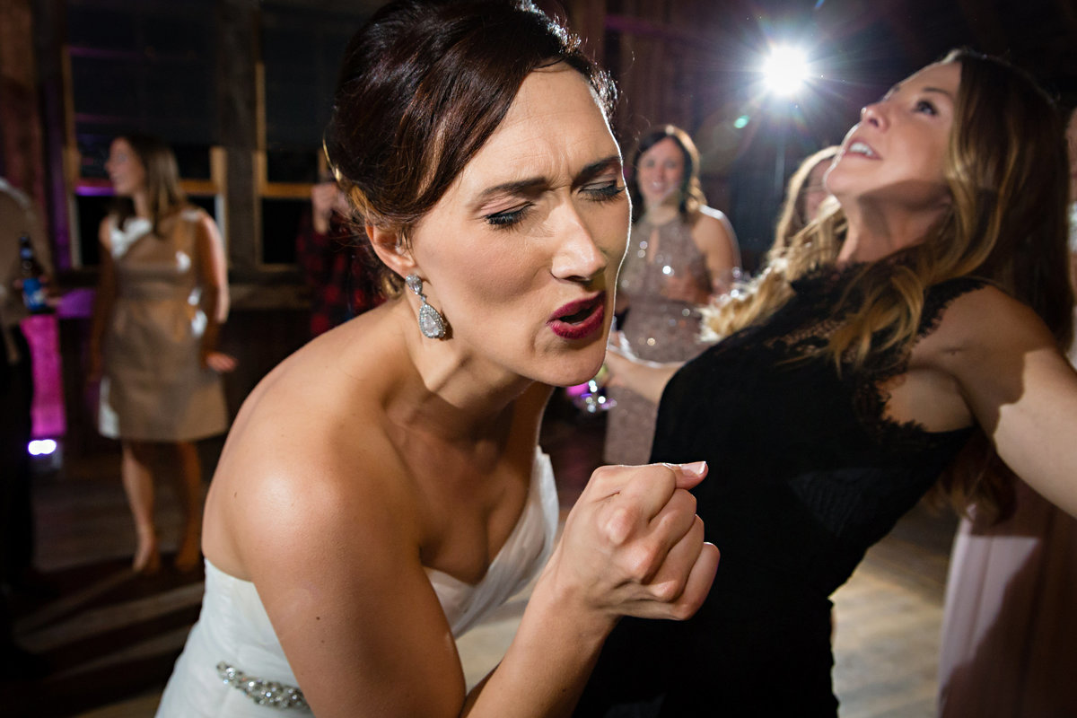 The bride sings along to a rap song at her wedding reception at Skinner Barn in Vermont
