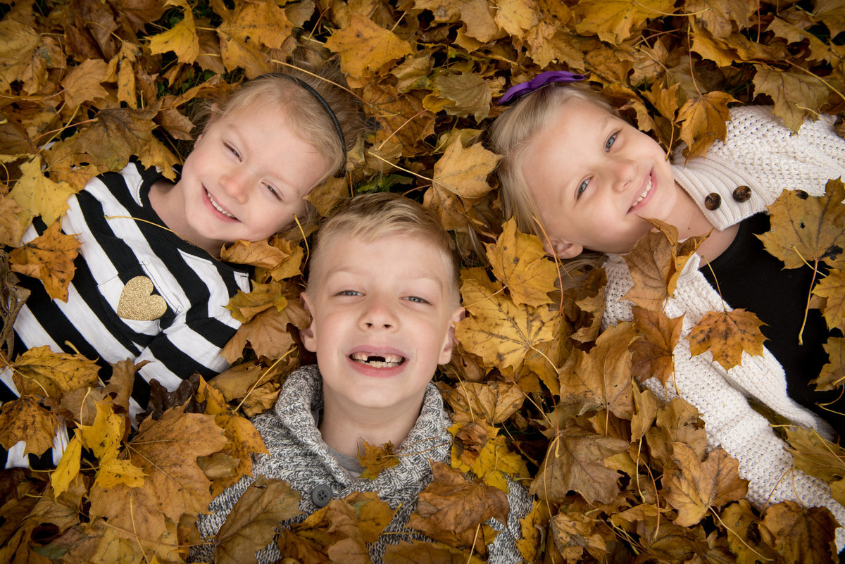 kids in fallen leaves on a crisp autumn day.