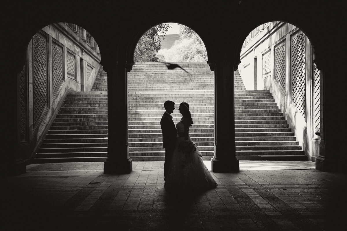 A bride and groom in silhouette at the Bethesda Terrace
