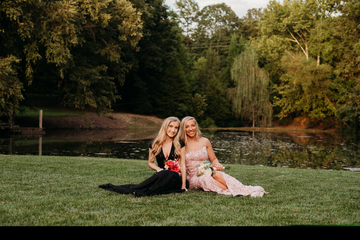 photo of two girls sitting in prom dresses