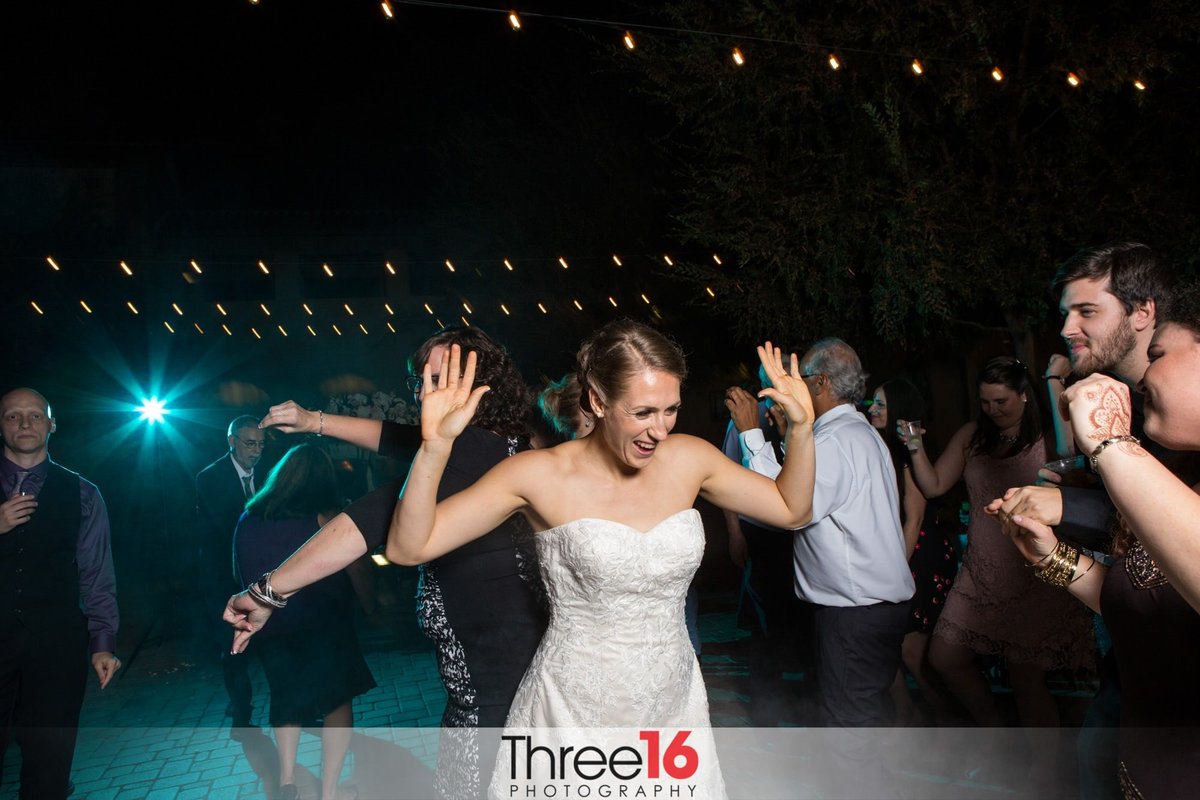 Bride dances with others at her reception