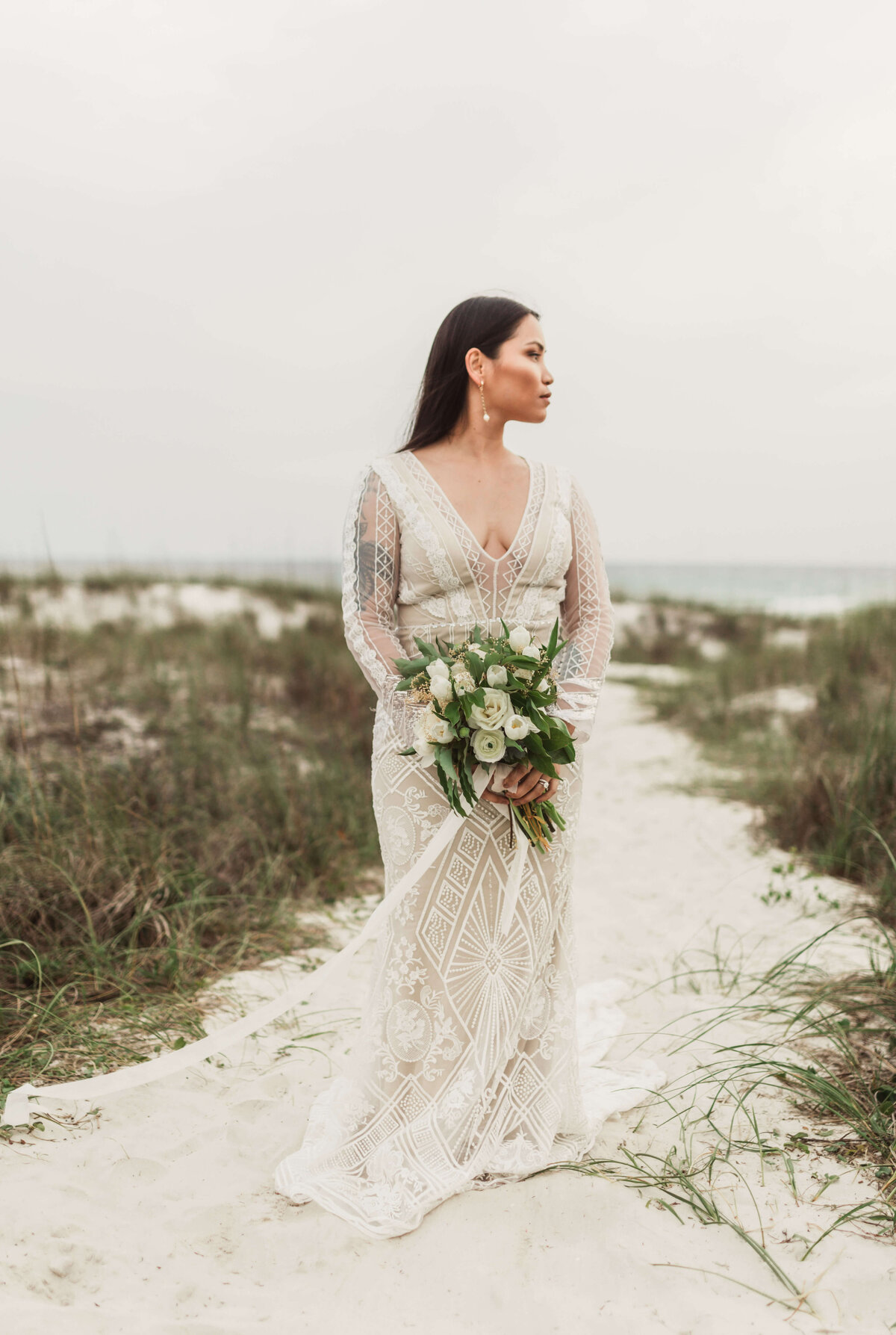 asian bride in bridal dress and veil walks on beach path - taken by panama city fl photographer Brittney Stanley