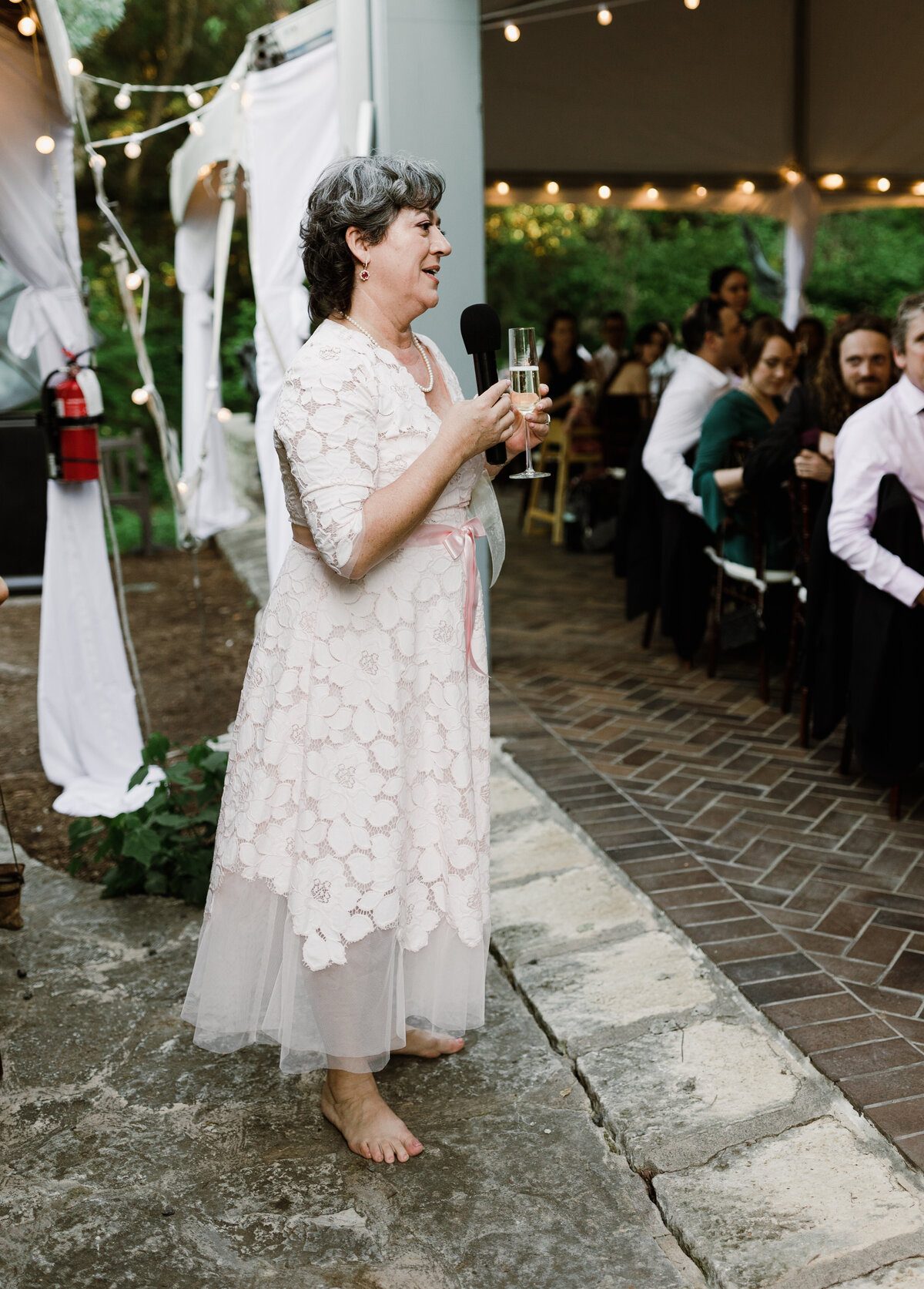 Woman making a speech at wedding reception at Umlauf Sculpture Garden, Austin