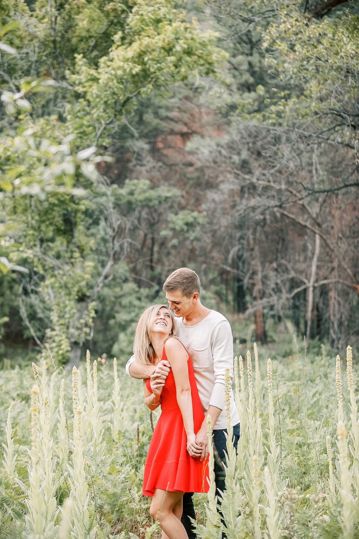 engaged-couple-laughing-in-sedona-field