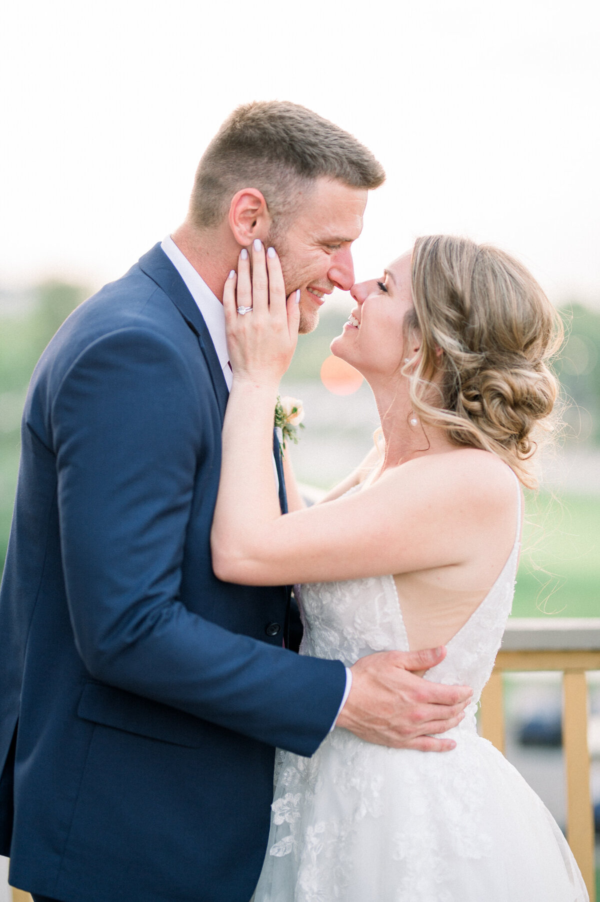 Bride and groom are nose to nose with big smiles on their face looking at each other. Captured by Niagara wedding photographer
