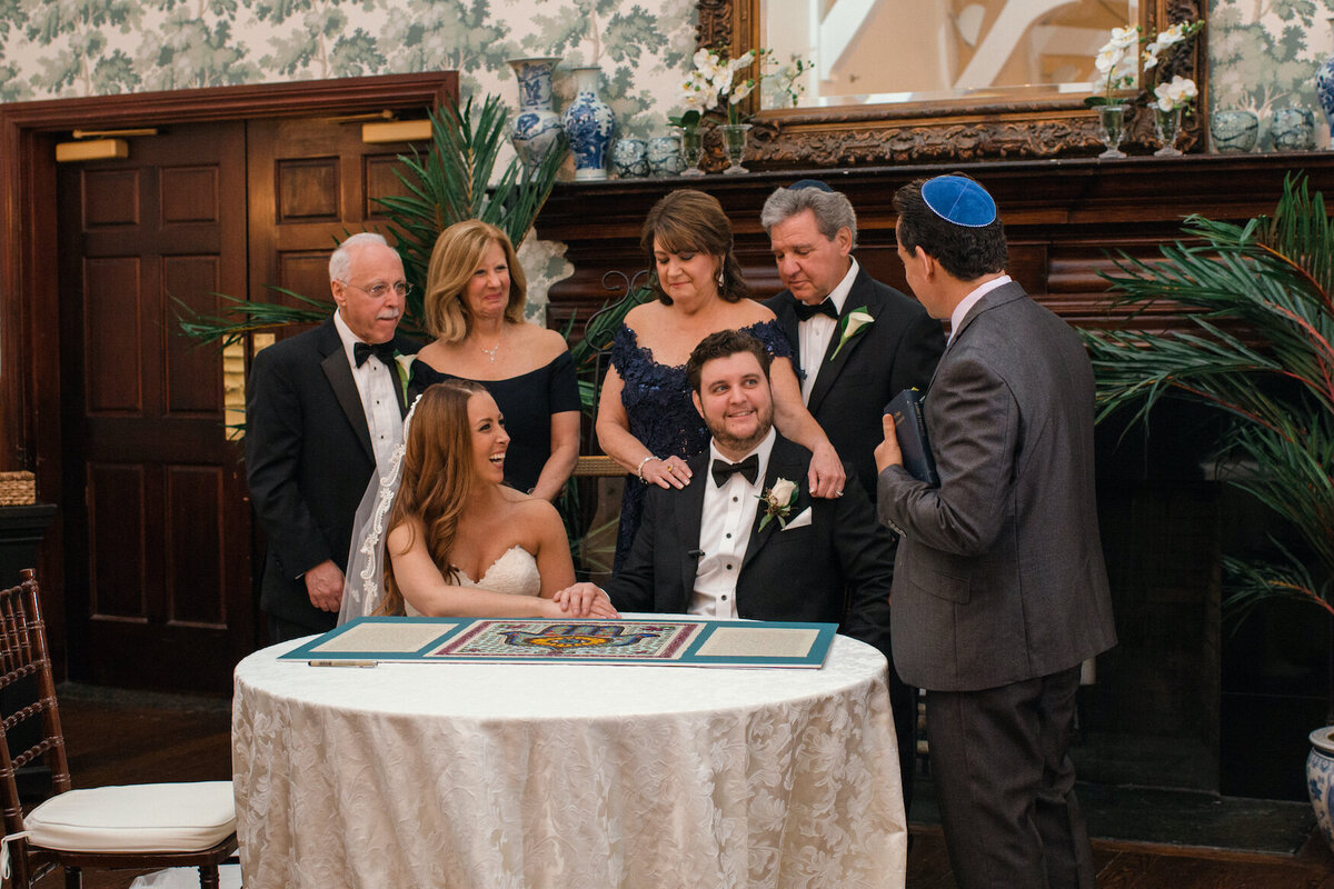 bride and groom signing the ketubah at Heritage Club at Bethpage