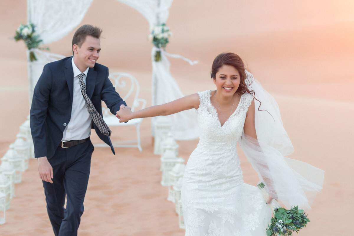 Wedding couple having fun during desert elopement shoot in Dubai organized by Lovely & Planned