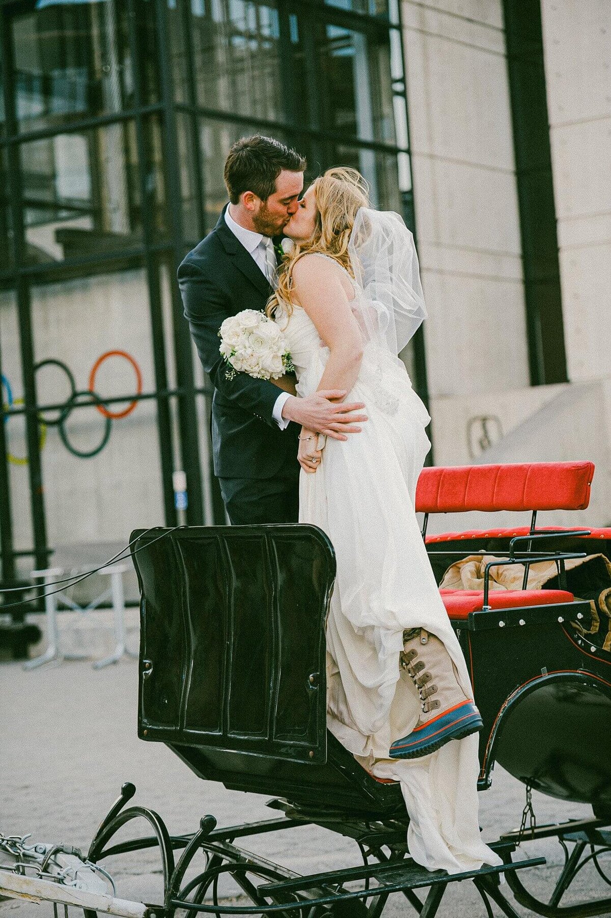 bride and groom kissing in a horse carriage at Palisades Tahoe