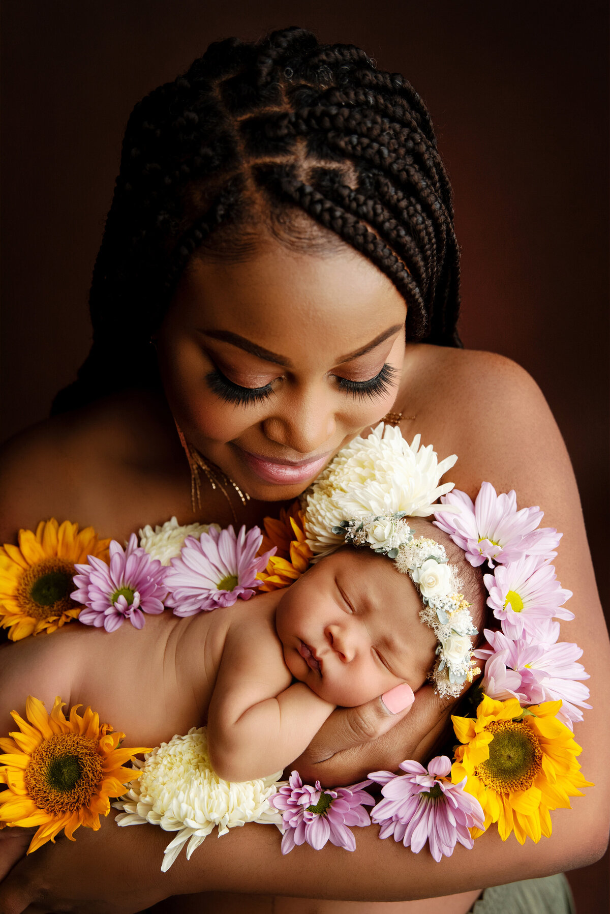 st-louis-newborn-photographer-mother-cradling-newborn-surrounding-by-fresh-flowers-and-wearing-a-flower-crown