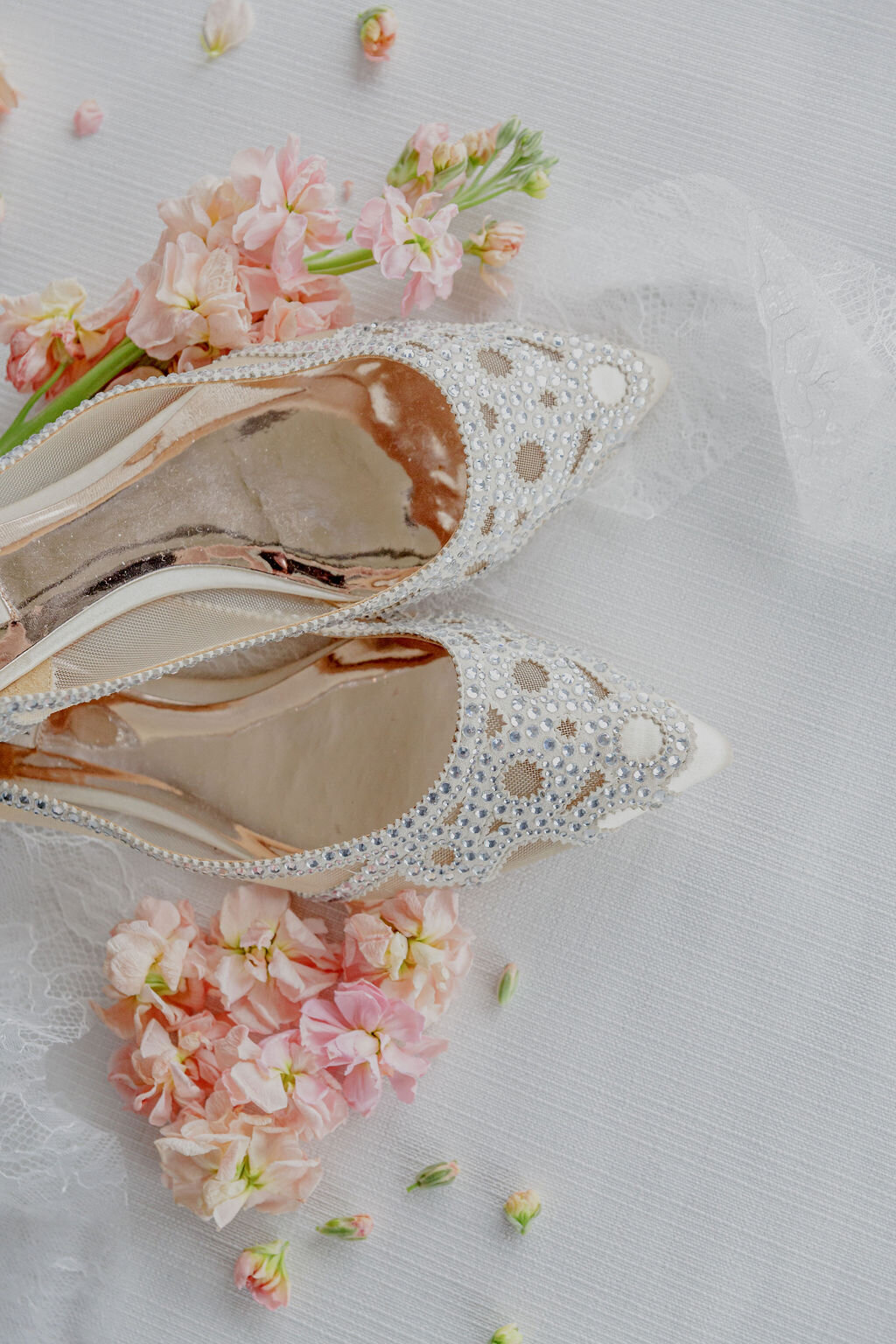 An artistic shot focusing on the bride's shoes with her holding up her dress, highlighting details of her wedding attire