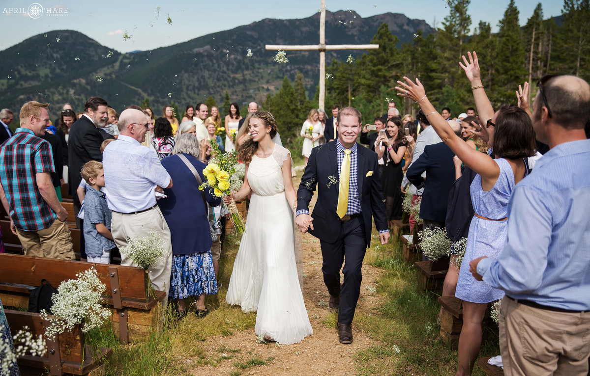 Happy Wedding Ceremony Recessional with Flower Petals Thrown at Couple at Mountain View Ranch YMCA of the Rockies  in Estes Park