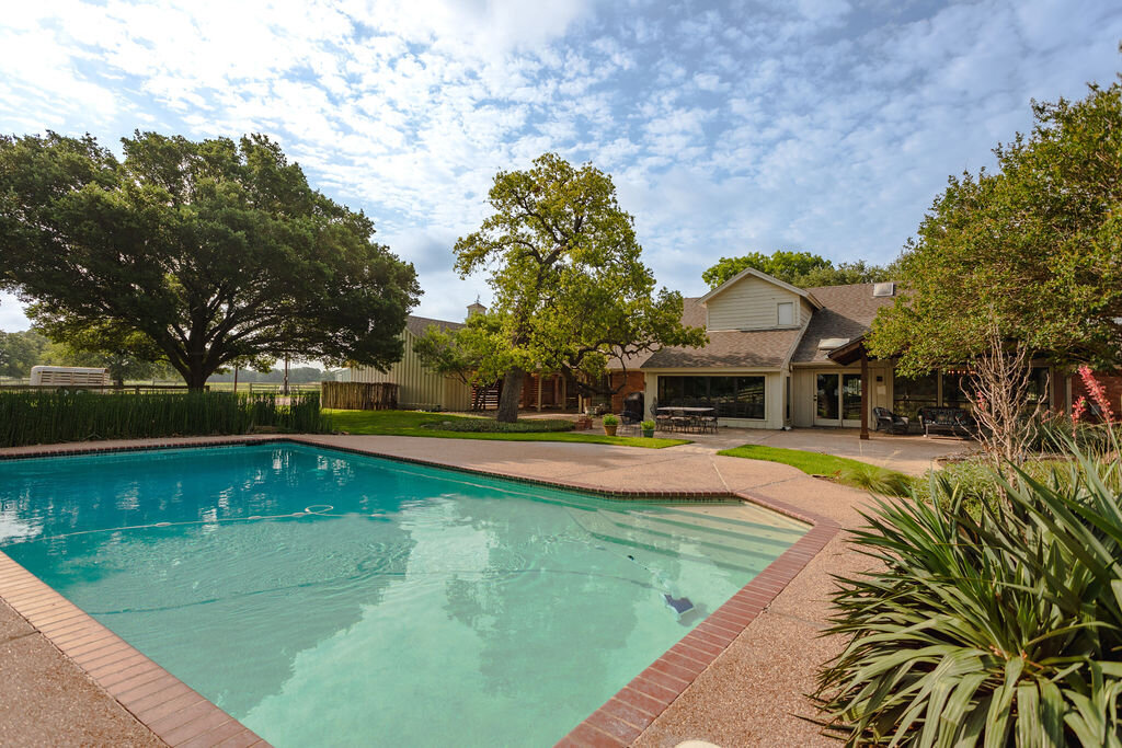 Outdoor swimming pool at this 5-bedroom, 4-bathroom vacation rental house for 16+ guests with pool, free wifi, guesthouse and game room just 20 minutes away from downtown Waco, TX.