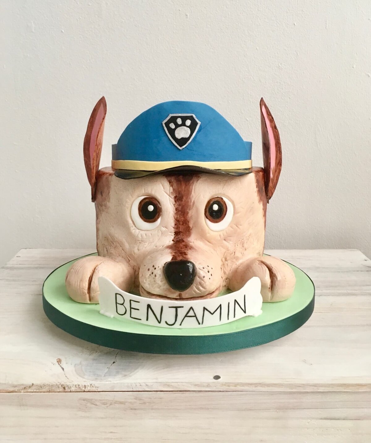 A Paw Patrol birthday cake where the cake looks like a dogs head with two paws