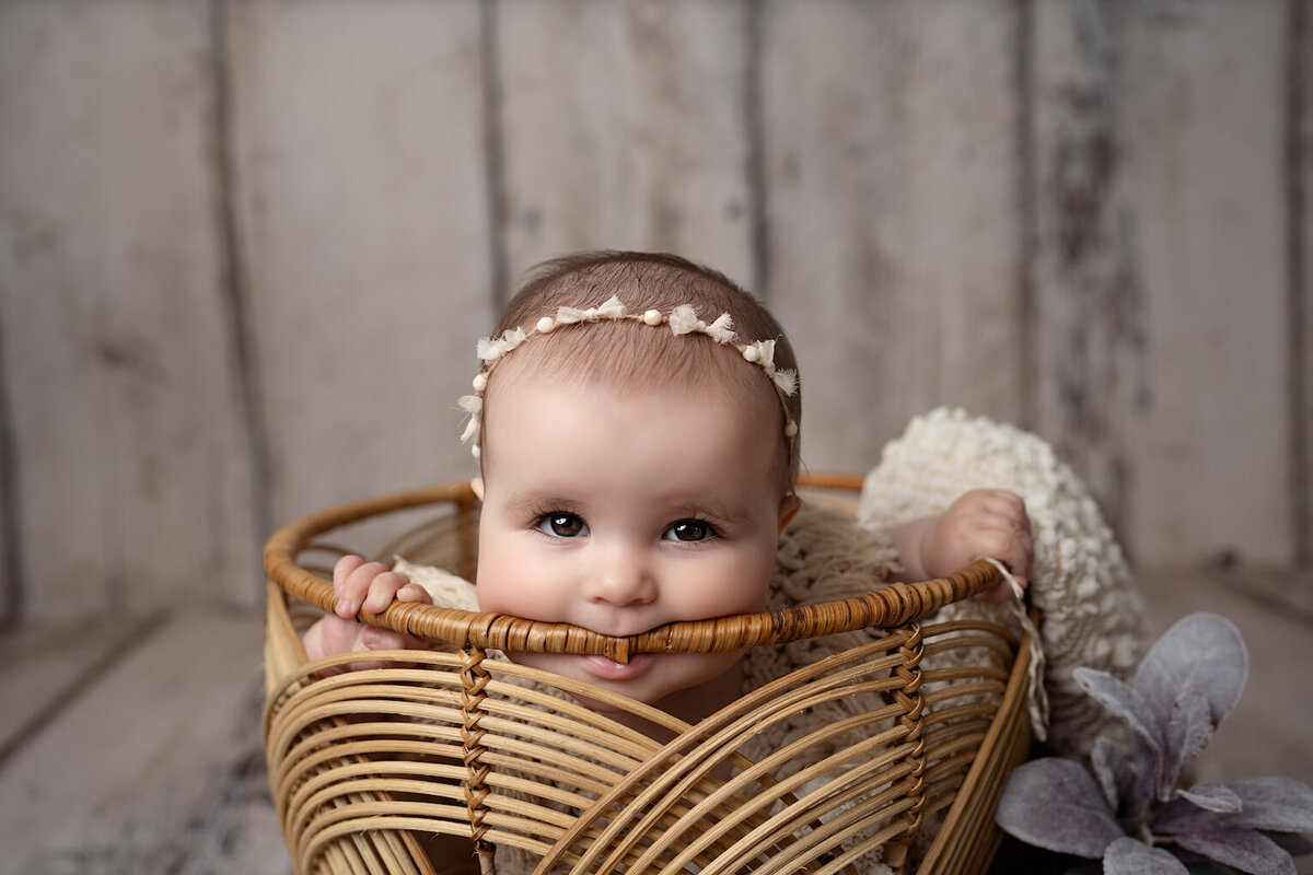 baby girl turns six months sitting in basket by for the love of photography Lansing