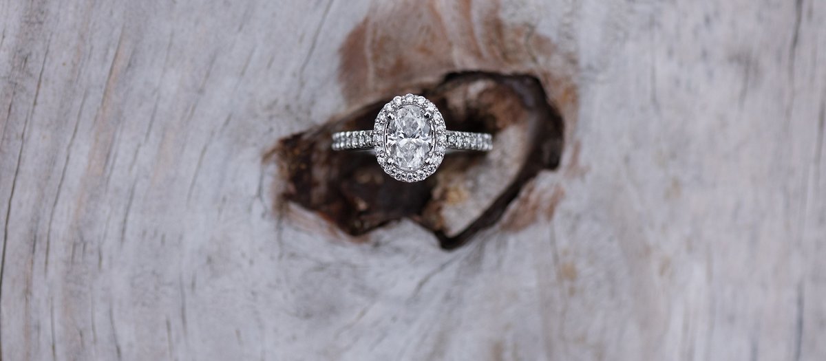 Oval cut diamond ring with halo in wood knot photo