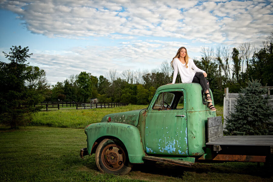 senior girl with vintage truck in field