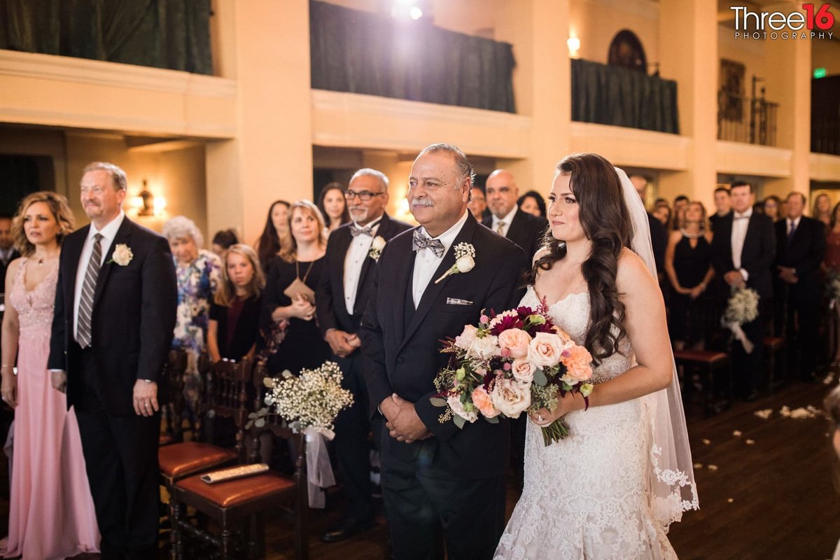 Father escorts his daughter down the aisle of her wedding