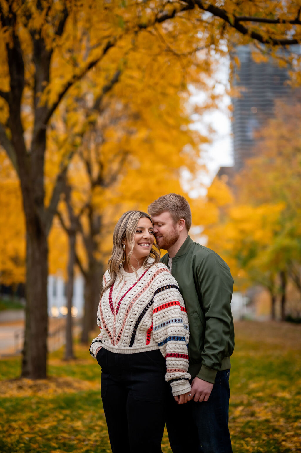 A couple embrace in Grant Park with fall colors