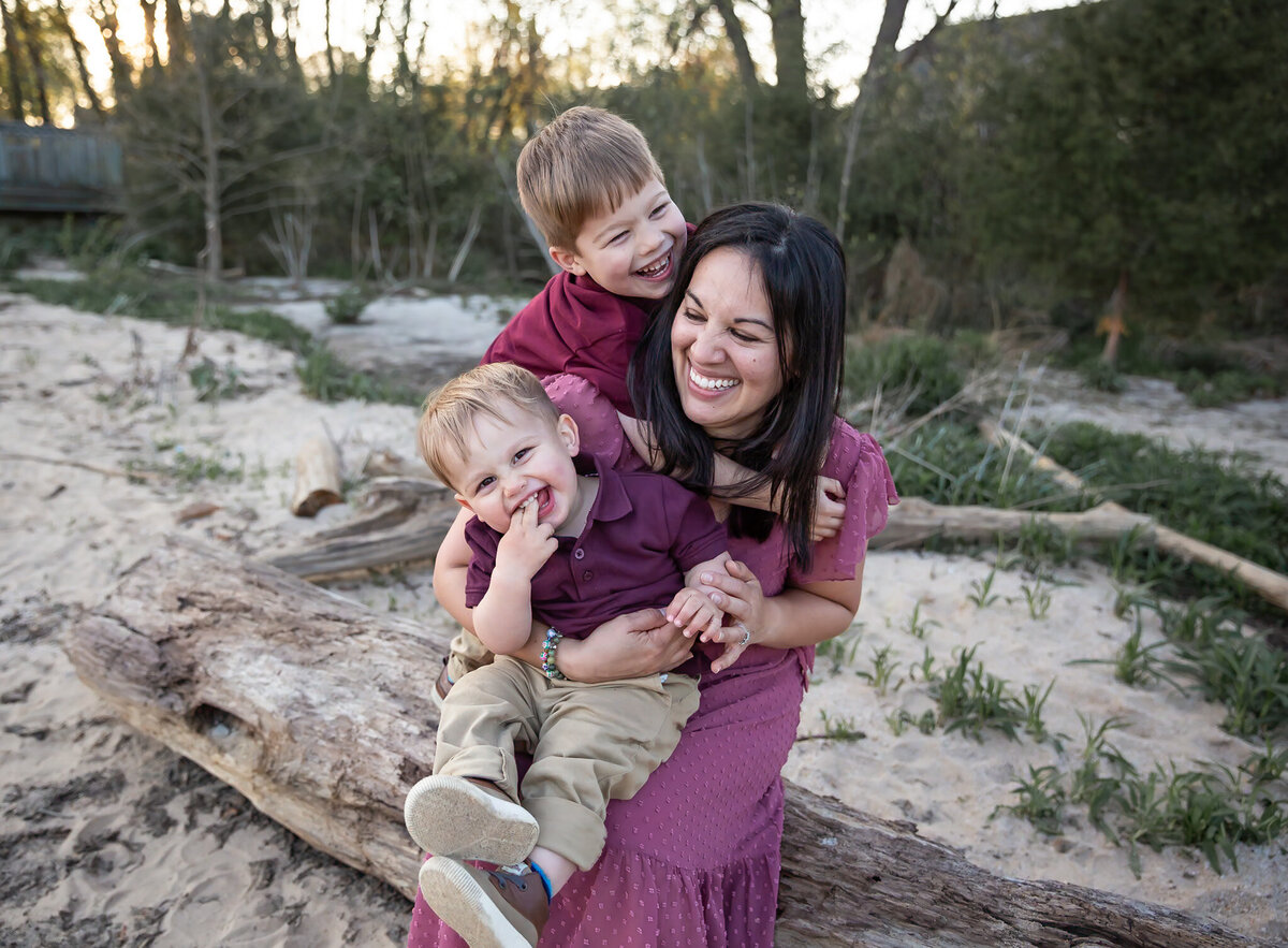 Mother get huts and tickles from her children while they all laugh during lifestyle family photos in Harford County, Maryland