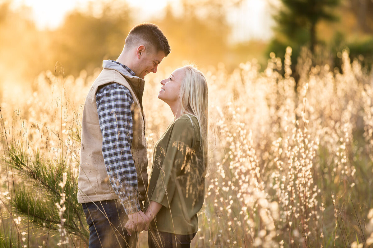 couple photo in a field at sunset golden hour