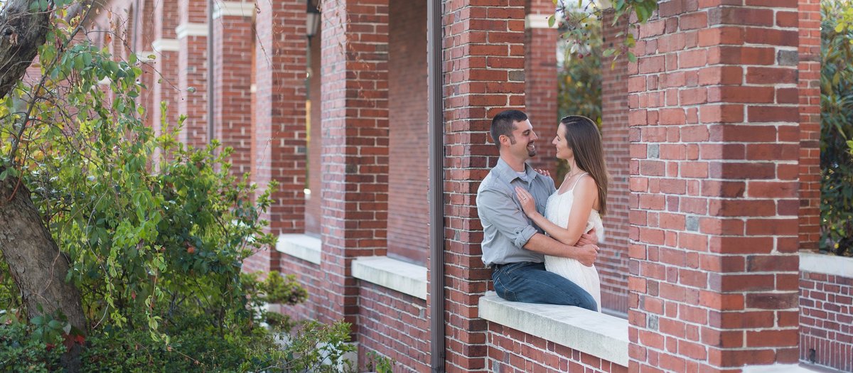 Couple looking at each other in brick arches on Burke Rehabilitation Hospital's campus in White Plains, NY photo