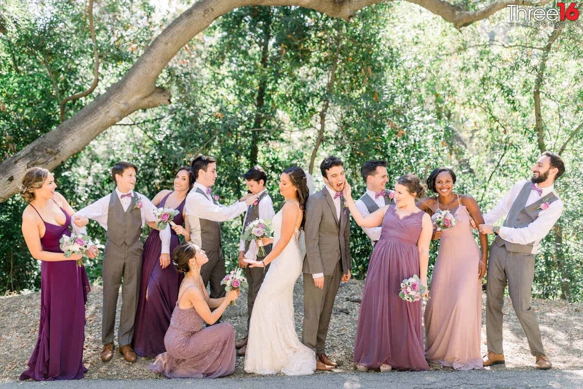Bride and Groom pose with their wedding party while everyone acts silly