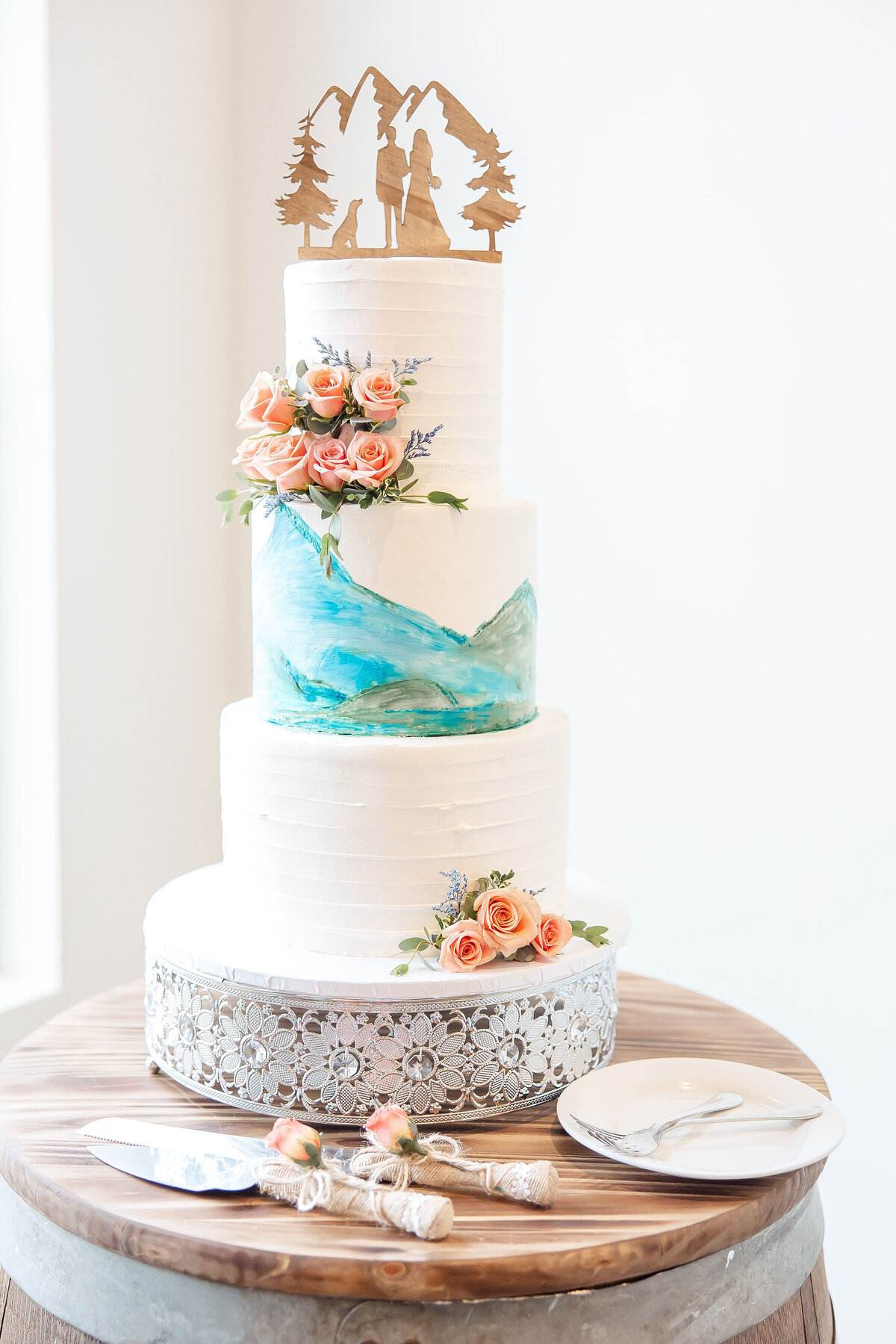 wedding cake with painted mountains  and wooden topper at Hayes Hollow Hidden Falls in Spring Branch Texas