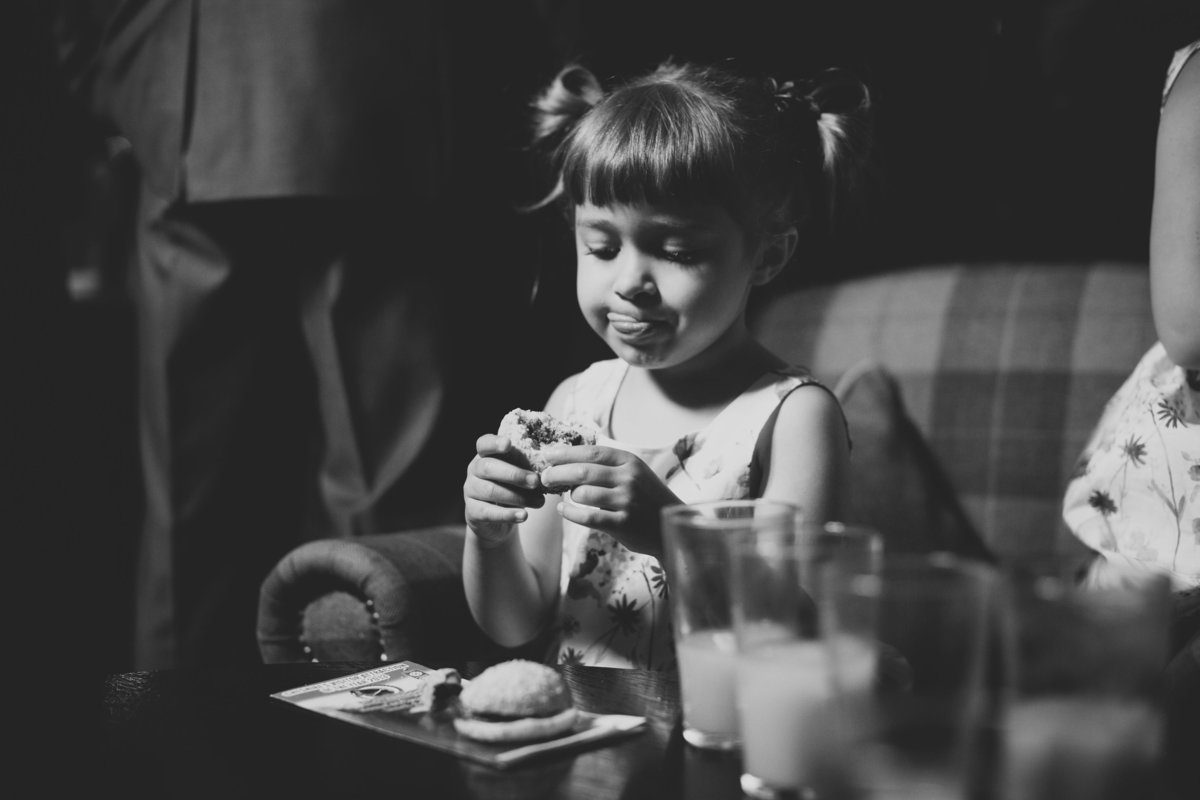 girl eating mini burger at wedding