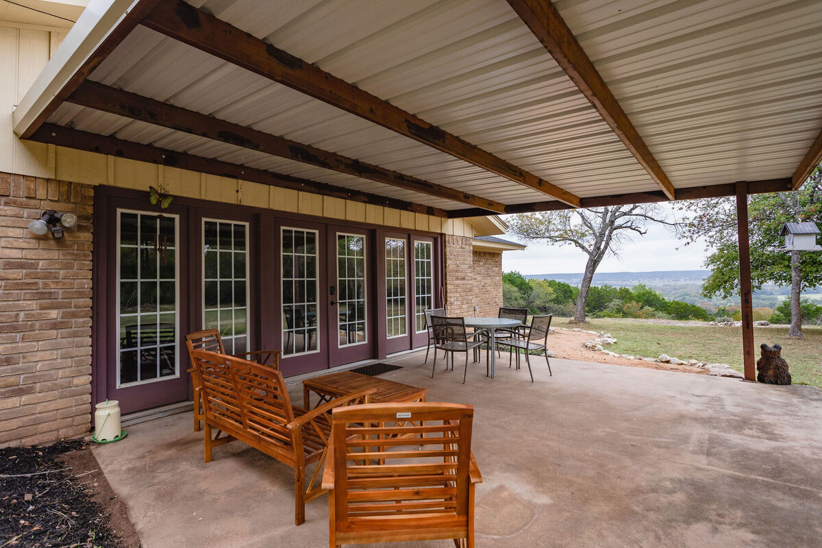 Covered porch with multiple seating options at this three-bedroom, two-bathroom ranch house for 7 with incredible hiking, wildlife and views.