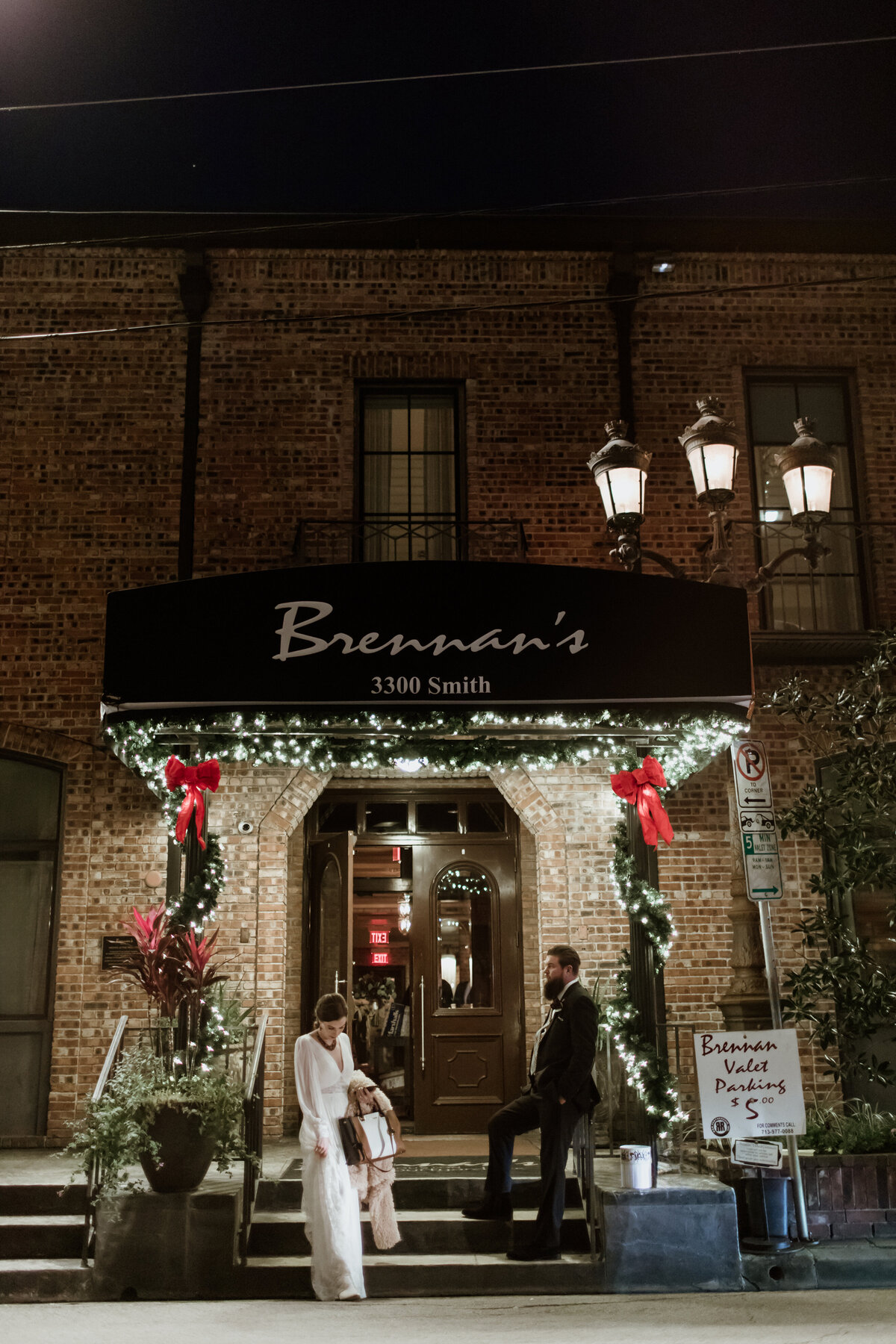 It’s the end of the night and a bride and groom casually stand outside Brennan’s restaurant in Houston Texas. Captured by Fort Worth Wedding Photographer, Megan Christine Studio