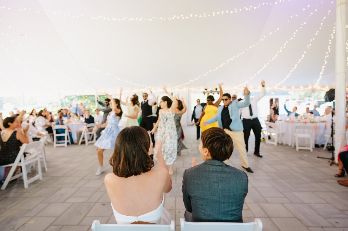 Couple watching wedding guests dance at wedding reception, done by Unique Melody Events & Design (New England Wedding Planners)