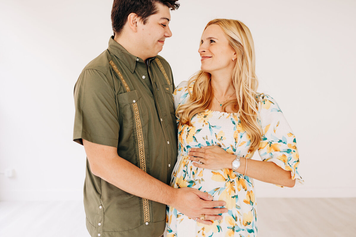 couple holding a baby bump to take a newborn photography announcement