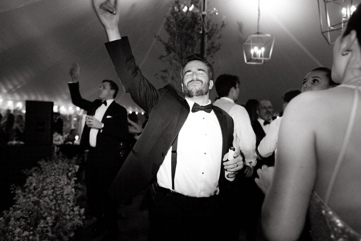 A man is dancing merrily with the other guests at the wedding reception at Lion Rock Farm, CT. Image by Jenny Fu