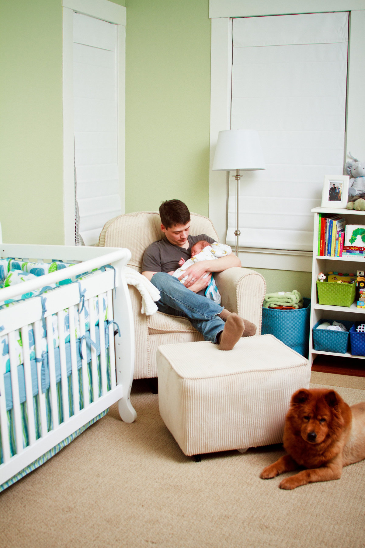 In home newborn photography session in San Antonio with Father, son, and dog in the nursery.